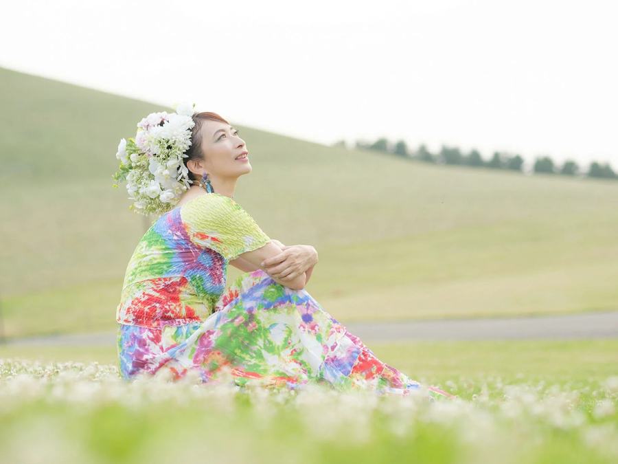 草原で空を見上げる高橋貴子・元写真